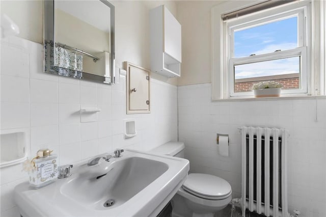 bathroom with radiator, sink, and toilet