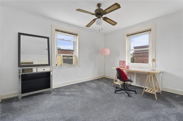 office space featuring cooling unit, ceiling fan, plenty of natural light, and dark colored carpet