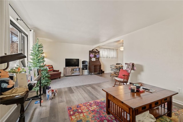 living area with baseboards and wood finished floors