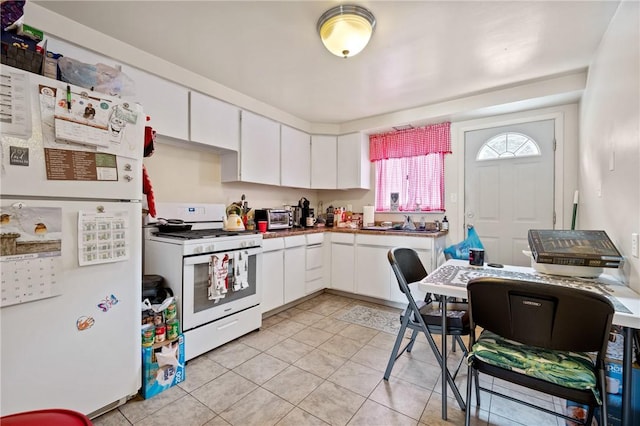 kitchen featuring white cabinetry, light tile patterned floors, and white appliances