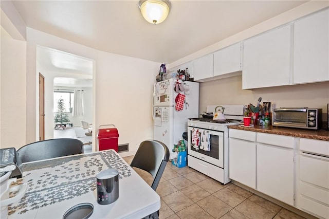 kitchen with white cabinetry, white appliances, and light tile patterned floors