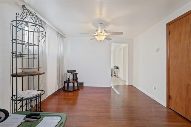 interior space with dark wood-type flooring and ceiling fan