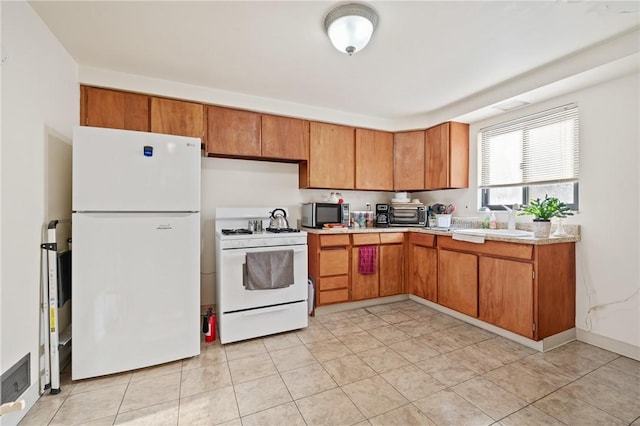 kitchen featuring sink, white appliances, and light tile patterned flooring