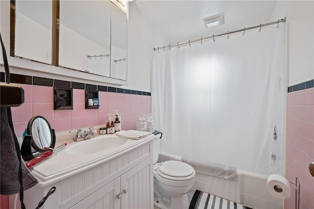 full bathroom featuring vanity, toilet, shower / tub combo, and tile walls