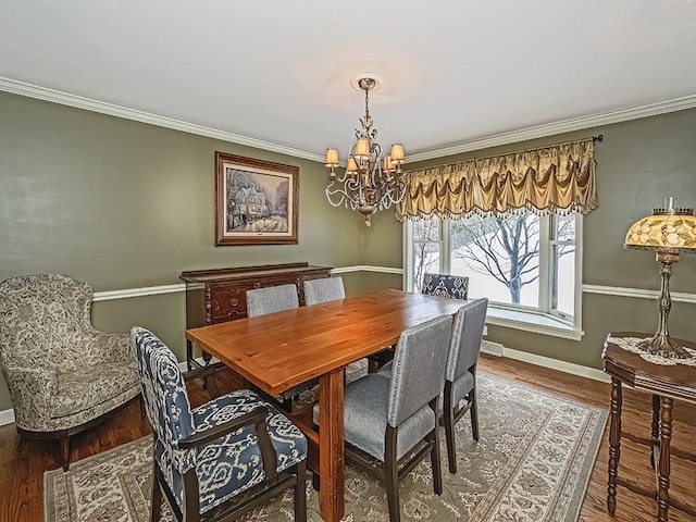 dining room with ornamental molding, hardwood / wood-style floors, and an inviting chandelier