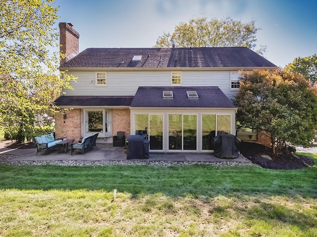 back of property with a yard and a patio area