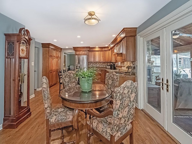 dining area featuring sink, light hardwood / wood-style flooring, and french doors