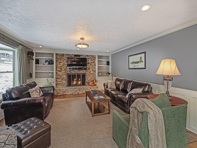 living room with built in features, ornamental molding, a stone fireplace, and a textured ceiling