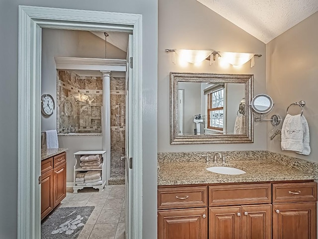 bathroom with vanity, lofted ceiling, tile patterned floors, and a textured ceiling