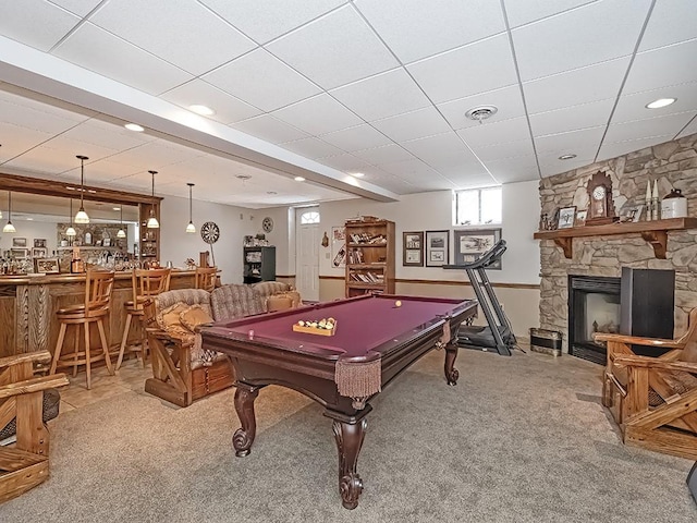 recreation room with a fireplace, bar, pool table, light carpet, and a drop ceiling