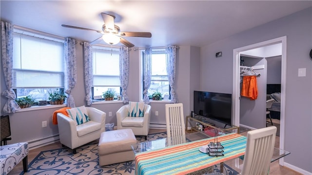 living room featuring a baseboard heating unit, a baseboard radiator, ceiling fan, and baseboards