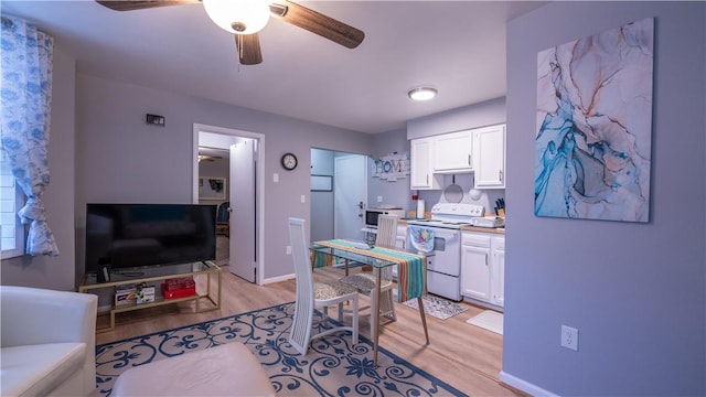 kitchen featuring light wood-style floors, white electric range, and white cabinetry