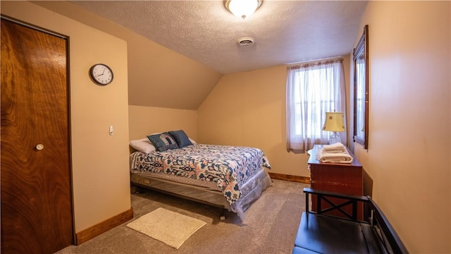 carpeted bedroom featuring baseboards, visible vents, vaulted ceiling, and a textured ceiling