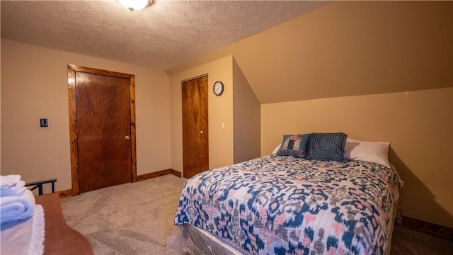 bedroom with a closet, carpet flooring, a textured ceiling, and baseboards