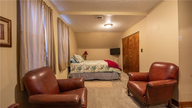 bedroom with lofted ceiling, carpet floors, a textured ceiling, and visible vents