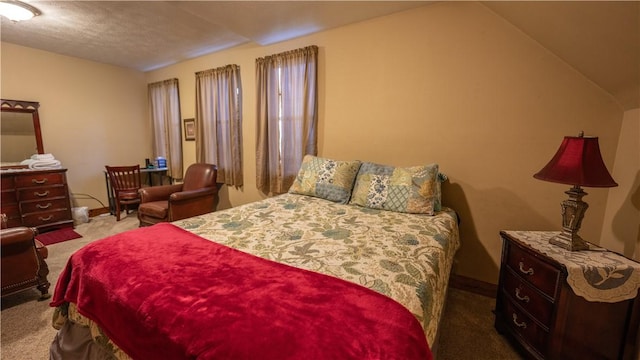 bedroom featuring lofted ceiling, baseboards, and carpet floors