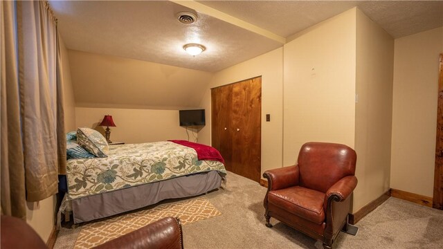 carpeted bedroom featuring lofted ceiling, a textured ceiling, visible vents, and baseboards