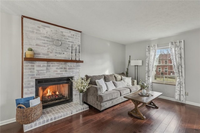 living room with a brick fireplace, dark hardwood / wood-style floors, and a textured ceiling