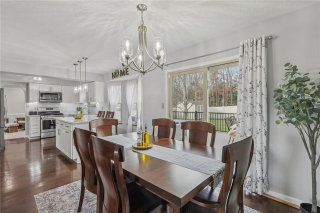 dining room featuring dark hardwood / wood-style flooring, sink, and an inviting chandelier