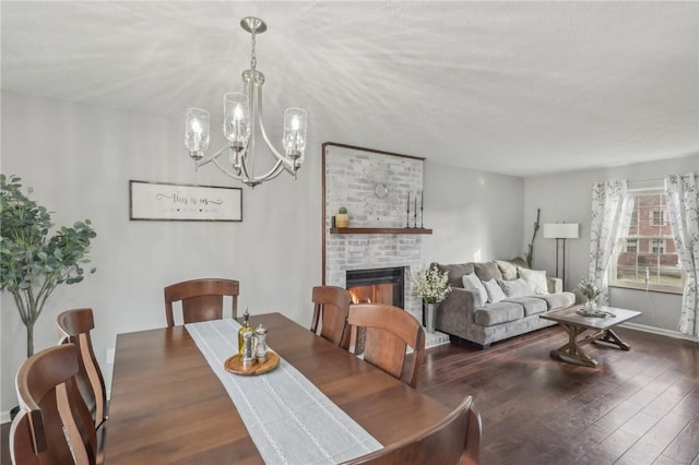 dining room featuring a brick fireplace, dark hardwood / wood-style floors, and a chandelier