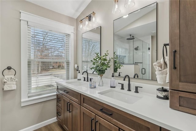 bathroom featuring vanity, a shower with shower door, vaulted ceiling, and hardwood / wood-style floors