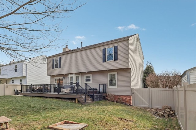 rear view of house featuring a wooden deck and a yard