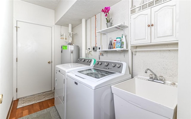 laundry area with sink, dark wood-type flooring, washer and clothes dryer, and water heater