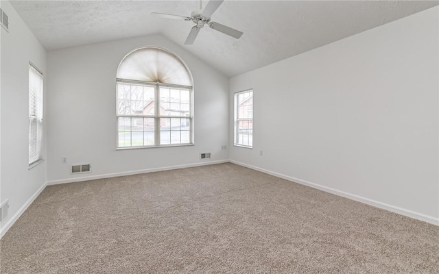 unfurnished room with ceiling fan, lofted ceiling, carpet flooring, and a textured ceiling