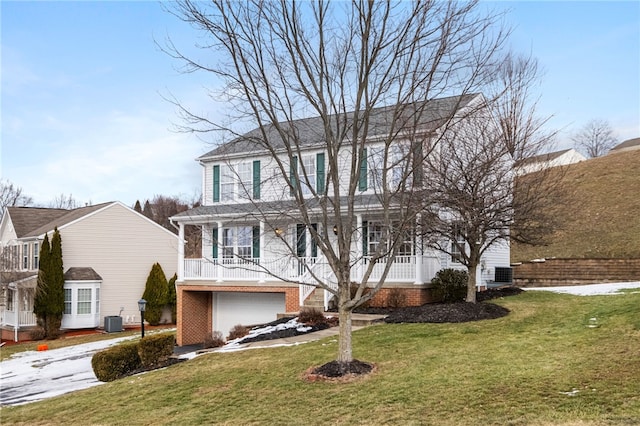 view of front of house featuring a garage, central AC, and a front lawn