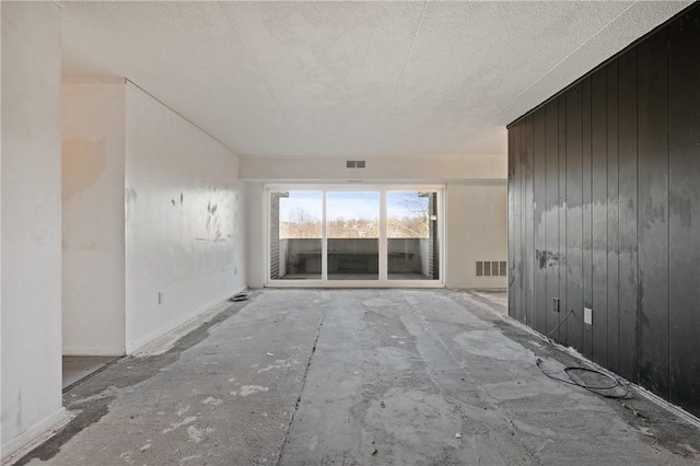 unfurnished room with wood walls