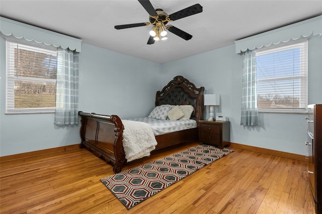 bedroom featuring baseboards, wood-type flooring, and a ceiling fan