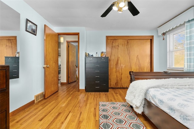 bedroom featuring visible vents, a ceiling fan, a closet, light wood finished floors, and baseboards