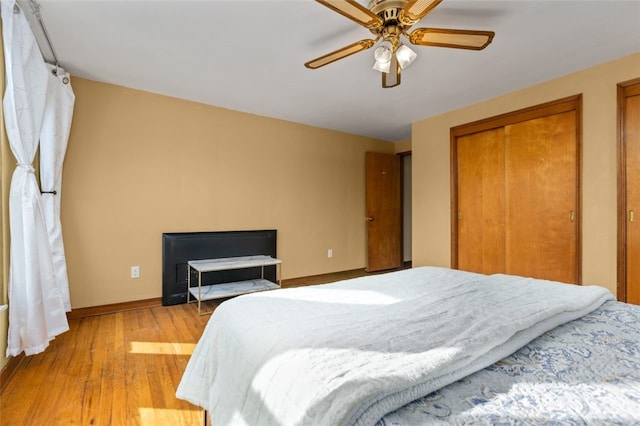 bedroom with light wood-type flooring, baseboards, and ceiling fan