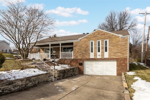 ranch-style home with brick siding, covered porch, a garage, stone siding, and driveway