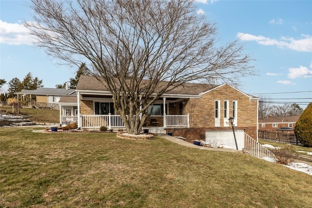 view of front of property featuring a garage, covered porch, a front yard, and fence