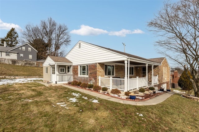 view of front of house featuring brick siding, covered porch, and a front lawn