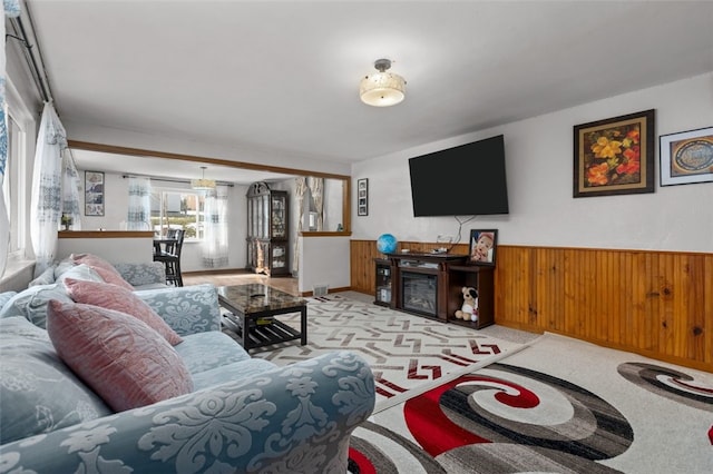 living area featuring carpet flooring, a wainscoted wall, and wood walls