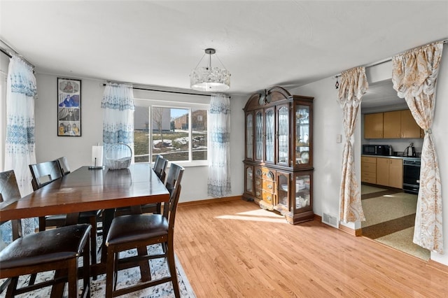 dining room with visible vents, light wood-style flooring, and baseboards