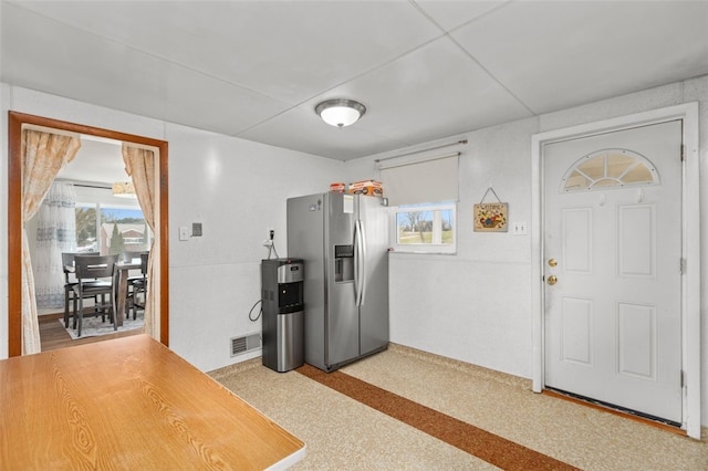 kitchen featuring visible vents and stainless steel refrigerator with ice dispenser