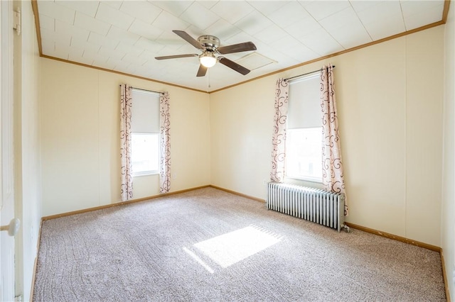 carpeted empty room featuring crown molding, radiator, and ceiling fan