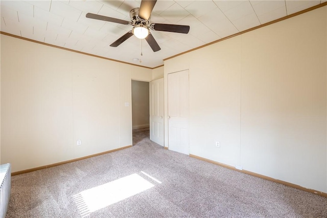 carpeted empty room featuring ornamental molding and ceiling fan