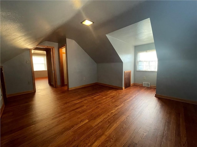 additional living space featuring lofted ceiling and hardwood / wood-style flooring