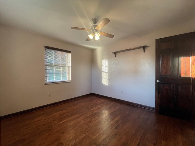 spare room with dark wood-type flooring and ceiling fan