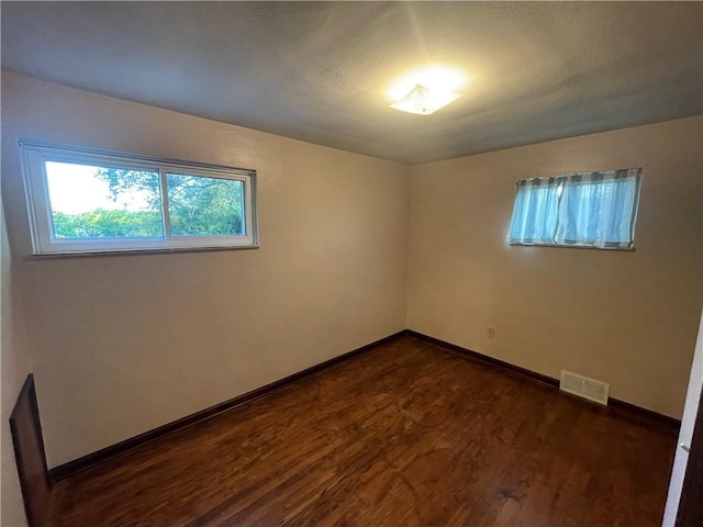 spare room with dark wood-type flooring