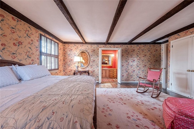 bedroom with connected bathroom and beam ceiling