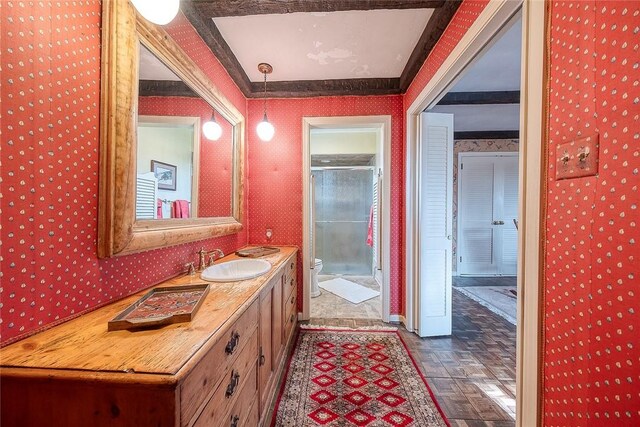 bathroom with a shower with door, vanity, parquet flooring, and toilet