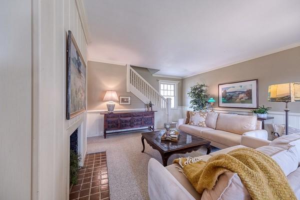 living room featuring ornamental molding and dark carpet