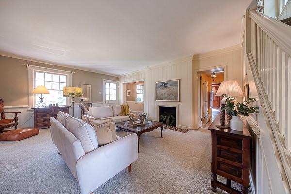 carpeted living room featuring crown molding