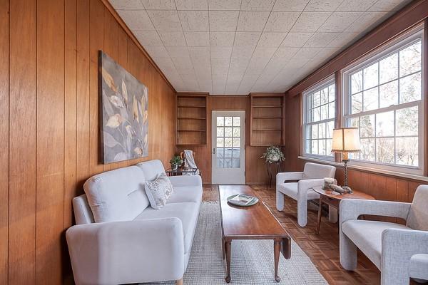 living area featuring parquet flooring and wood walls