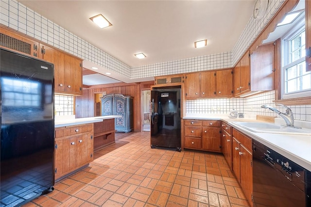 kitchen featuring sink, backsplash, and black appliances